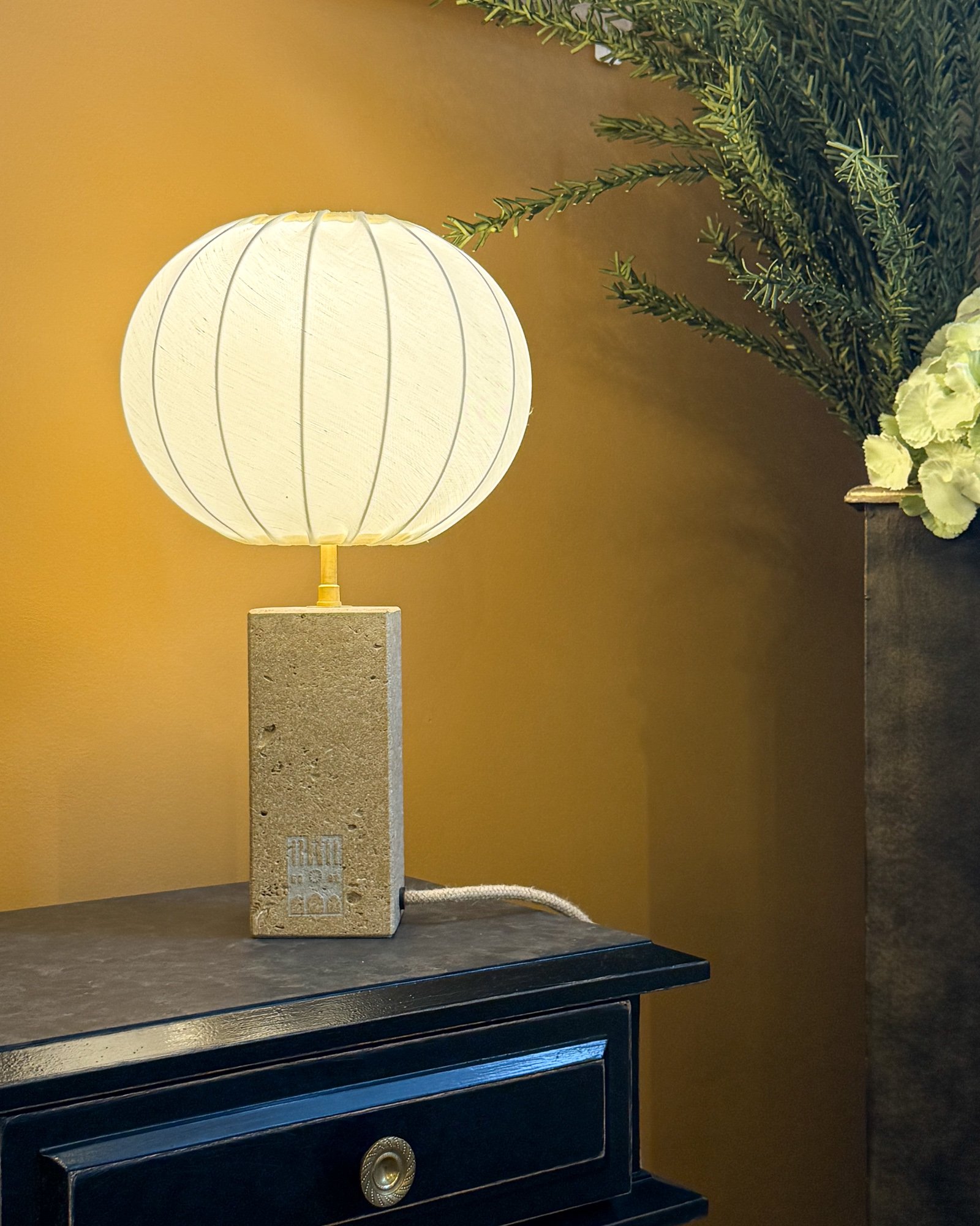 Mise en situation du luminaire Le Pinacle diffusant une lumière chaleureuse dans un intérieur haut de gamme