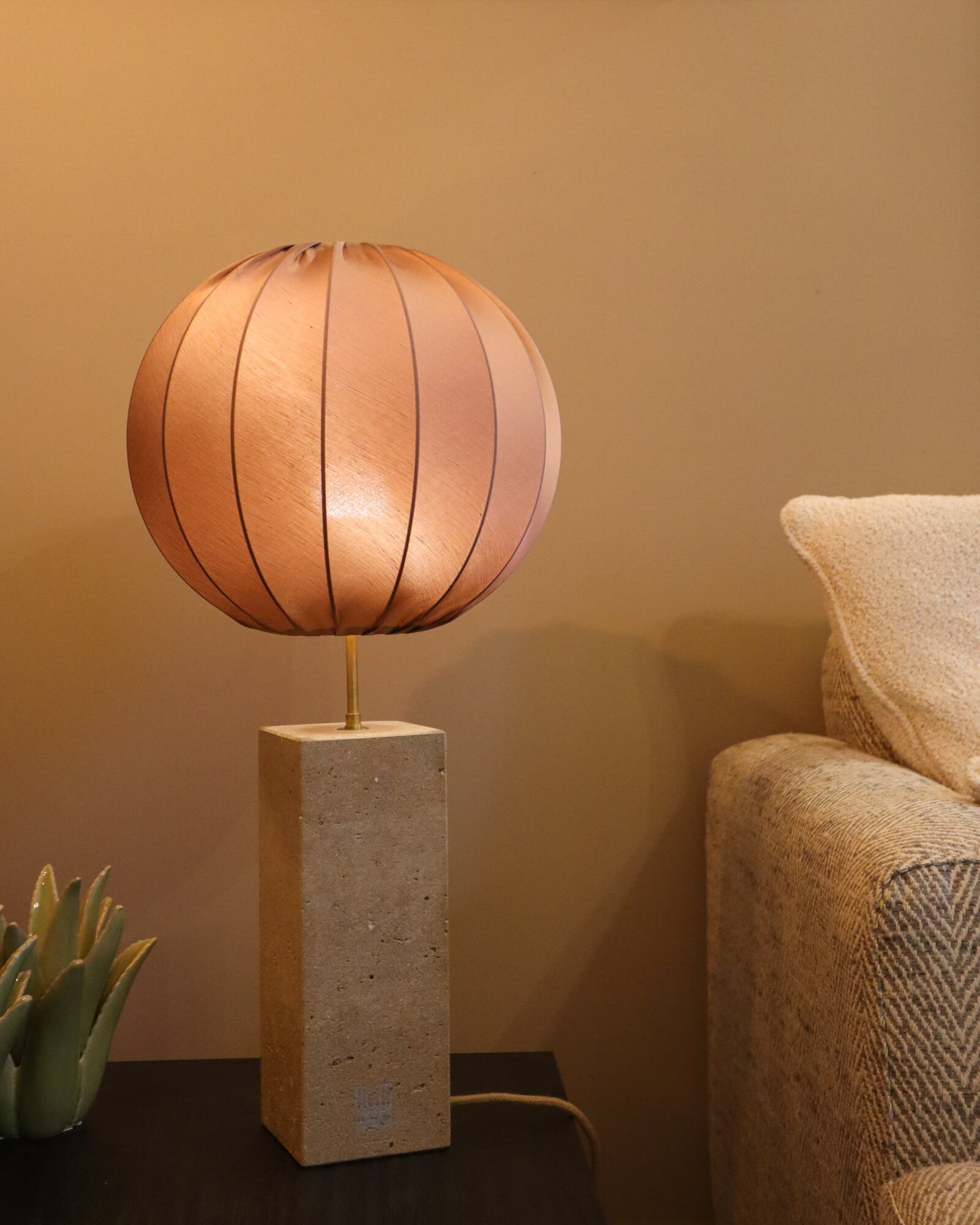 certificat-authenticite Le luminaire en pierre La Flèche, apportant une lumière douce et naturelle sur une table d'appoint